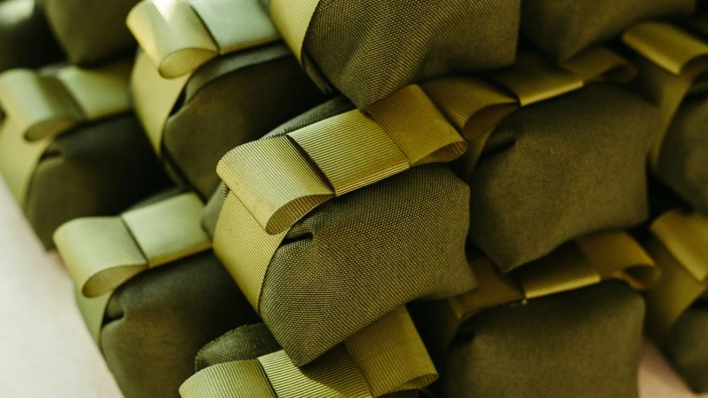 Helio Foods packaging system — olive-green tins with a minimal black wordmark on a sunlit counter.