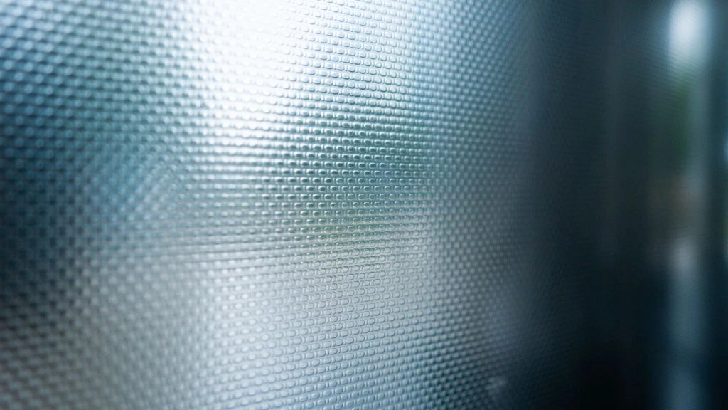 Verdant Capital reception — a sandblasted sans-serif wordmark on frosted glass in warm interior light.